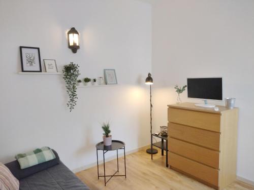 a living room with a couch and a tv on a dresser at City Inn Szigetvar in Szigetvár