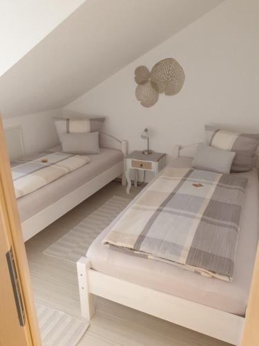ゾントホーフェンにあるFerienwohnung Litauの白いベッドルーム(ベッド2台、ソファ付)