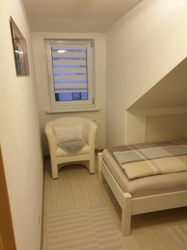 ゾントホーフェンにあるFerienwohnung Litauのベッドルーム1室(ベッド1台、椅子、窓付)
