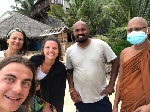 a group of people posing for a picture on the beach at The Alpha Monkey hotel & Tree house in Tangalle