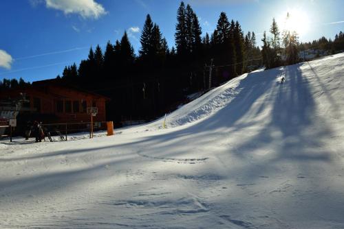 a snow covered ski slope with the sun in the background at Ubytování Skipot in Potŭčky