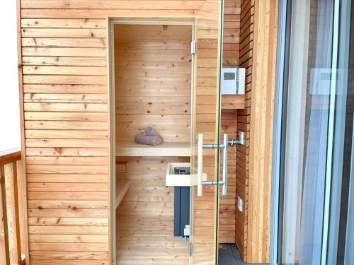 een houten sauna in een gebouw met een houten muur bij die Tauplitz Lodges - Alm Lodge A8 by AA Holiday Homes in Tauplitz
