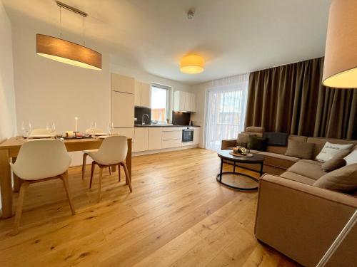 a living room with a couch and a table at die Tauplitz Lodges - Alm Lodge A8 by AA Holiday Homes in Tauplitz