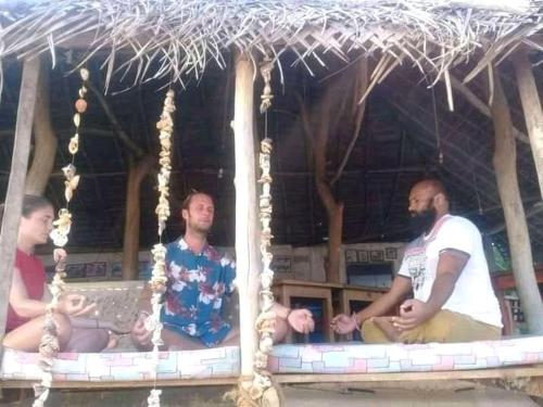 a group of three men sitting in a play house at The Alpha Monkey hotel & Tree house in Tangalle