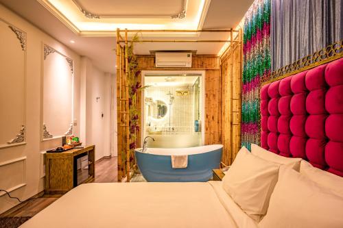 a bathroom with a bath tub and a bed at Mai Hotel in Hanoi