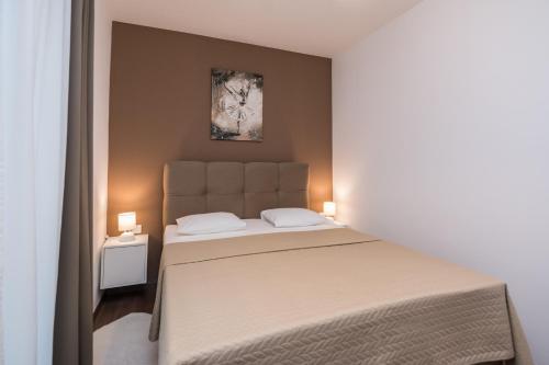 una camera da letto con un grande letto con due cuscini di Apartments Star a Zara (Zadar)