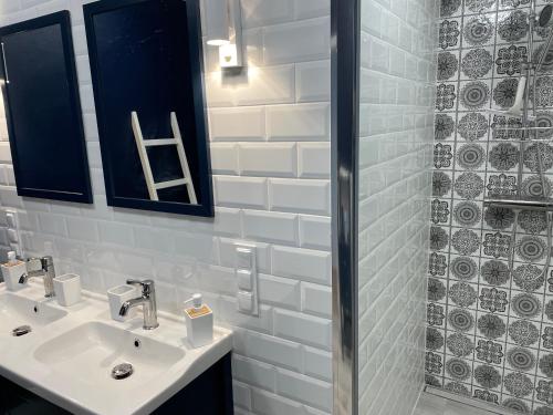 a white bathroom with a sink and a shower at Osada Parkowa, Kaszuby in Mściszewice