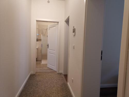 a hallway with white walls and a white door at FeWo am Jacobikirchhof in Stendal