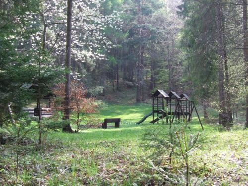 a park with a swing set in the grass at Czerwony Dwór in Krynica Zdrój