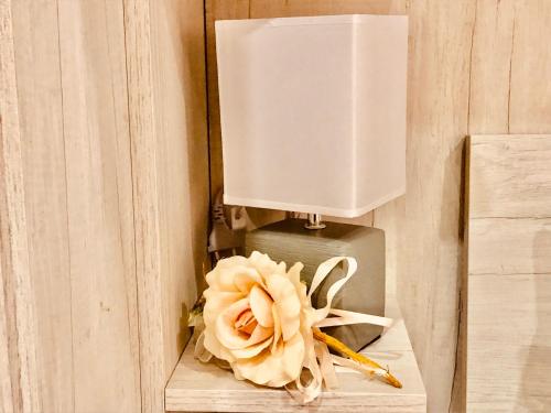 a lamp with a flower on a wooden table at YourHome - La Meta Perfetta Rooms&Spa in Meta