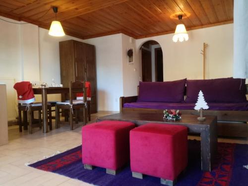 a living room with a purple couch and red stools at Kristis's Homes - "Beautiful Home" in Dimitsana in Dimitsana