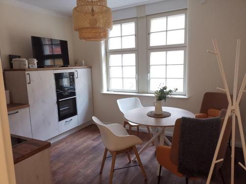 cocina y sala de estar con mesa y sillas en FeWo am Jacobikirchhof, en Stendal