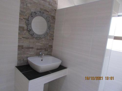 ein Bad mit einem Waschbecken und einem Spiegel in der Unterkunft Aloes Lodge in Leribe