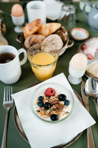 a table with a plate of breakfast food and a cup of coffee at Langebjerg Pension & Spisested in Allinge