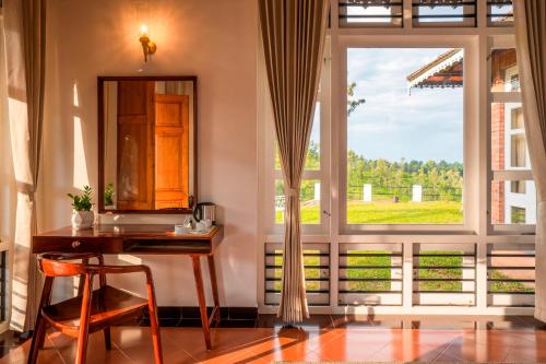 a room with a desk and a large window at Zostel Homes Wayanad (Vythiri) in Wayanad