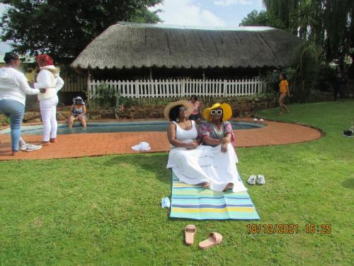 a woman sitting on a chair holding a child at Aloes Lodge in Leribe