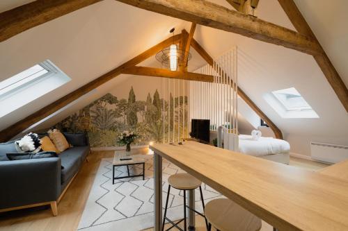 Cette chambre dispose d'une mezzanine avec un canapé et une table. dans l'établissement L'Entre-Deux Honfleur, à Honfleur