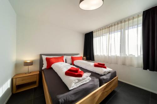 ein Schlafzimmer mit einem Bett mit roten Kissen darauf in der Unterkunft Chalet Altishofen in Riederalp
