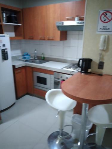 cocina con encimera, mesa y fregadero en Apartment 209, en Santiago