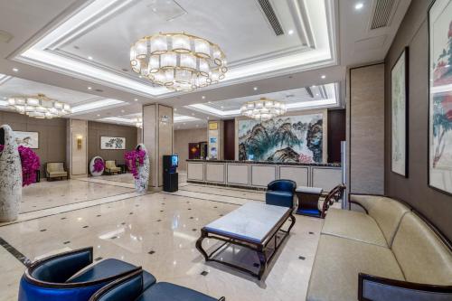 a lobby with a waiting room with blue chairs at Huzhou Wealth Hotel in Huzhou