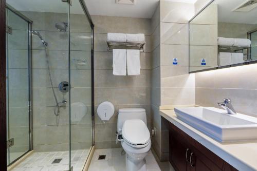 a bathroom with a toilet and a sink and a shower at Huzhou Wealth Hotel in Huzhou