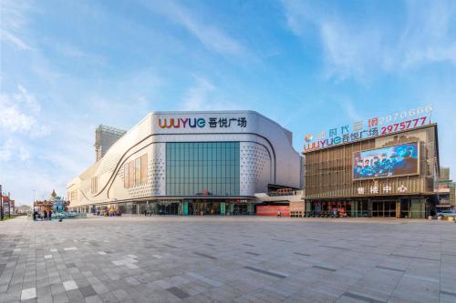 a large building with a sign on the side of it at Huzhou Wealth Hotel in Huzhou