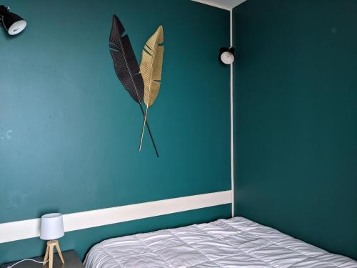 une chambre dotée d'un mur bleu avec un cerf-volant papillon sur le mur dans l'établissement Saint-Etienne Appart'hôtel de Bellevue, à Saint-Étienne