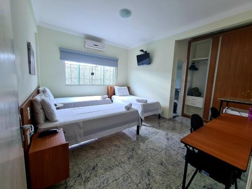 a living room with a bed and a couch at Hotel Flor de Minas in Uberaba