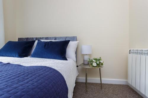 una camera con un letto blu e bianco e un tavolo di Luxury Burgess Apartments close to Soton General Hospital a Southampton