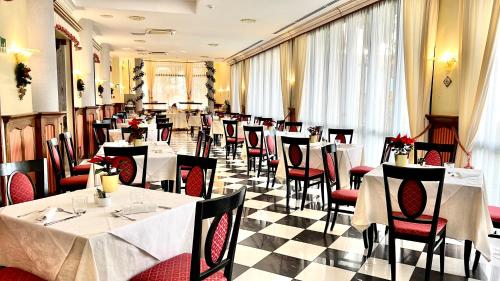 a restaurant with white tables and red chairs at Villa Felcaro - Relais, Lodge & Restaurant in Cormòns