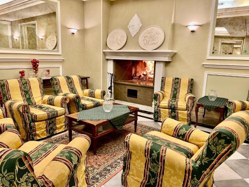 a living room with couches and a fire place at Villa Felcaro - Relais, Lodge & Restaurant in Cormòns