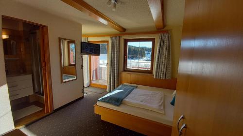 - une petite chambre avec un lit et une fenêtre dans l'établissement Pension Felsenheim, à Ramsau am Dachstein