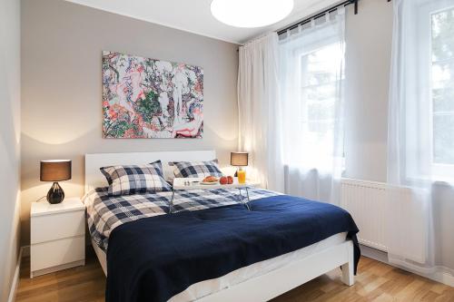 a bedroom with a bed with a blue blanket at Costa Apartments in Sopot