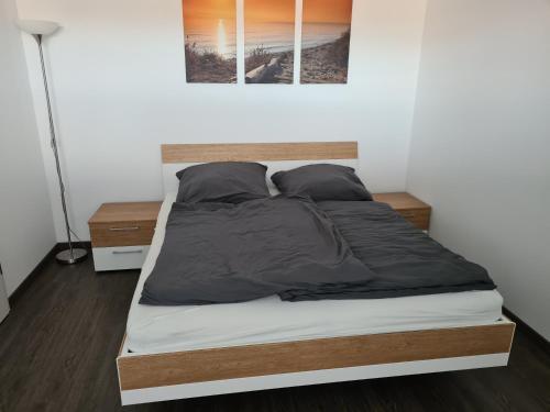 a bedroom with a large bed with black sheets and pillows at 1,5 ZKB Wohnung im Odenwald, an der Bergstraße mit tollem Ausblick in Rimbach
