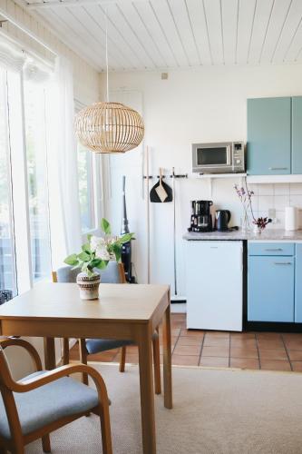 a kitchen with a table and a kitchen with a refrigerator at Langebjerg Pension & Spisested in Allinge