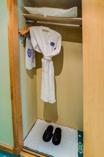 a closet with a pair of shoes and towels at Grand Continental Hotel in Abu Dhabi