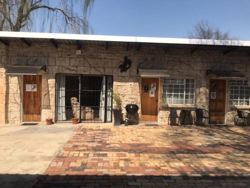 a stone building with two doors and a patio at Serenity Guesthouse in Klerksdorp