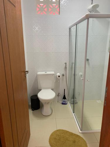 a bathroom with a toilet and a glass shower at Suíte Peixe Espada in Praia do Forte