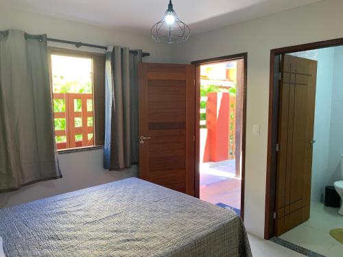 a bedroom with a bed and a sliding glass door at Suíte Peixe Espada in Praia do Forte