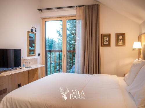 Habitación de hotel con cama grande y ventana en Vila Park Bujtina, en Prizren