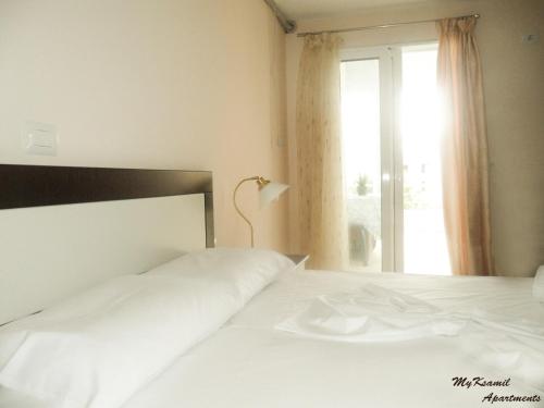 a bedroom with two white beds and a window at MyKsamil Apartments in Ksamil