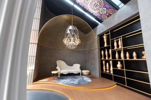 Zimmer mit einem weißen Stuhl und einem Kronleuchter in der Unterkunft Near MITEC, Arte Mont Kiara by Cobnb in Kuala Lumpur