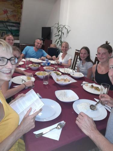 a group of people sitting around a table eating food at Daffodils Inn in Adams Peak