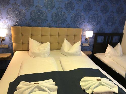 ein Hotelzimmer mit 2 Betten und Handtüchern darauf in der Unterkunft Arthotel Nagold in Nagold