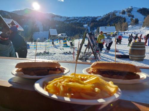 a table with three hot dogs and macaroni and cheese at Hotel Enzo Moro in Sùtrio