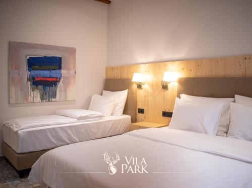 a hotel room with two beds and a painting at Vila Park Bujtina in Prizren