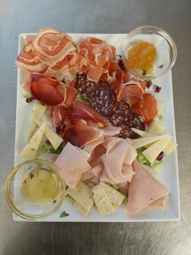 a plate of food with meat and cheese and sauce at Hotel Enzo Moro in Sùtrio