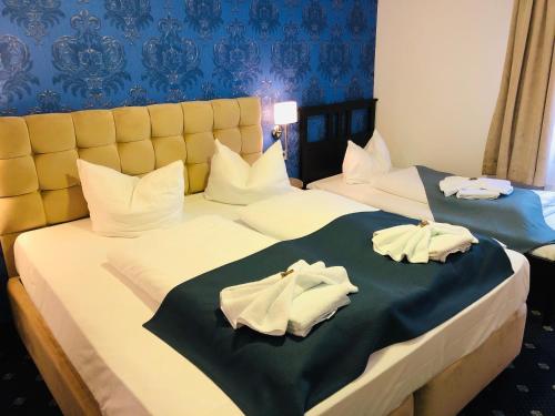 2 Betten in einem Hotelzimmer mit Handtüchern darauf in der Unterkunft Arthotel Nagold in Nagold