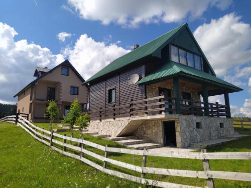 a house with a green roof and a fence at Holiday Home Darko in Žabljak