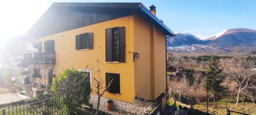 a yellow house with a black roof at Villa Ola in Barrea